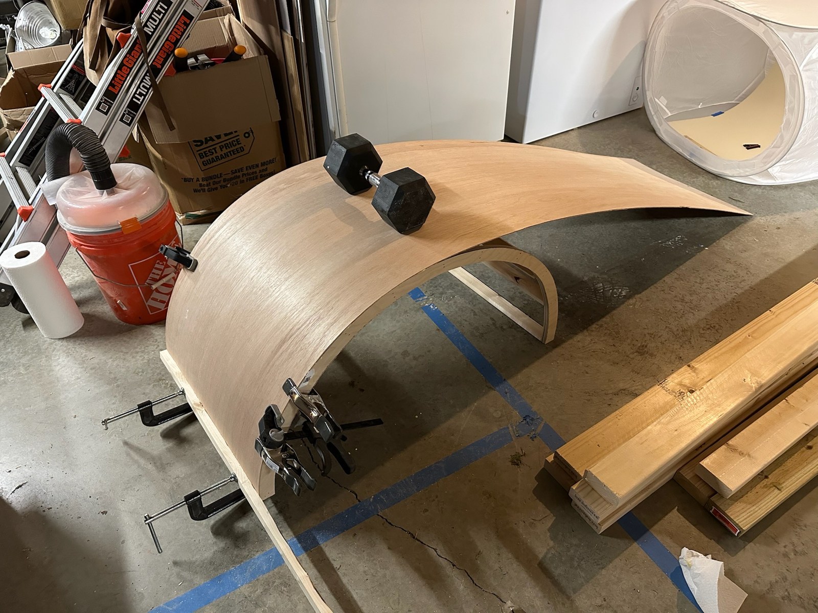 Curved wooden panel clamped to a form on the workbench