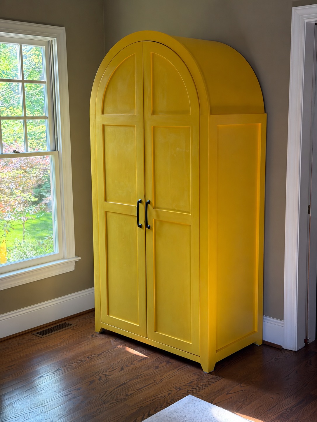 Bright yellow arched-top armoire in the kids’ playroom