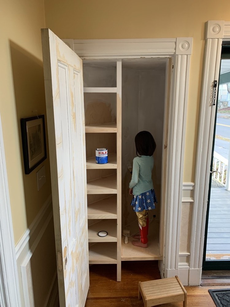 White shelving and hanging compartment during installation