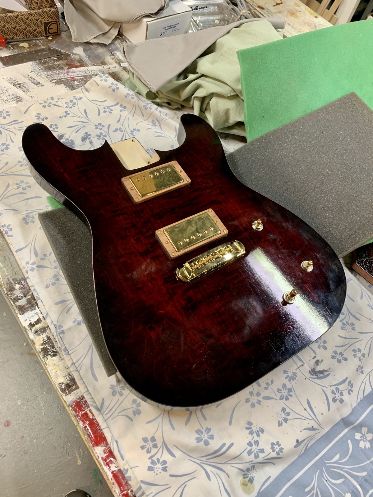 Glossy guitar body with gold pickups, bridge and controls installed