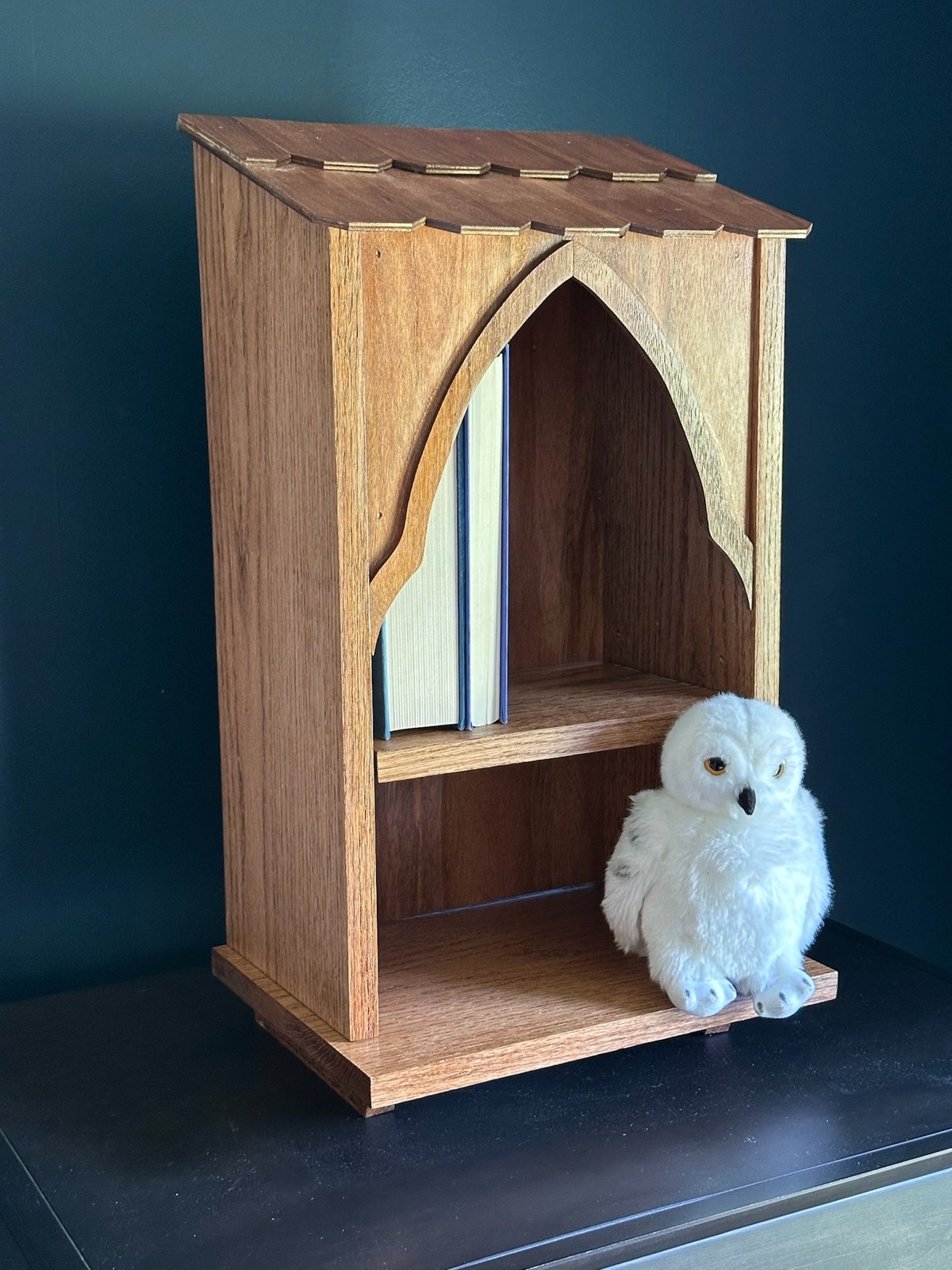 Completed wooden Owlery bookshelf with books and a stuffed white owl