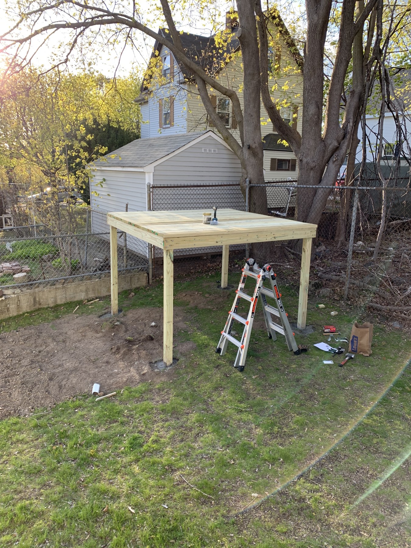 Raised wooden play structure platform beside a stepladder