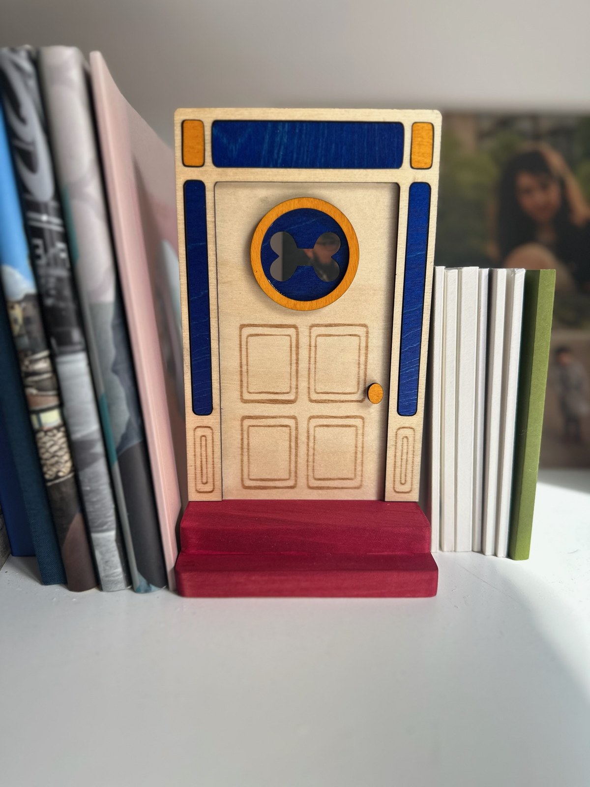 Handmade cartoon puppy inspired fairy door displayed between books